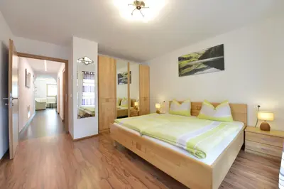 a bedroom with a large bed and a hallway at Ferienwohnung Haus Reider in Sarntal