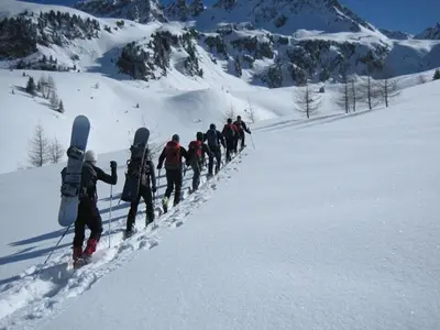 a group of people walking in the snow with snowboards at Ferienwohnung Haus Reider in Sarntal