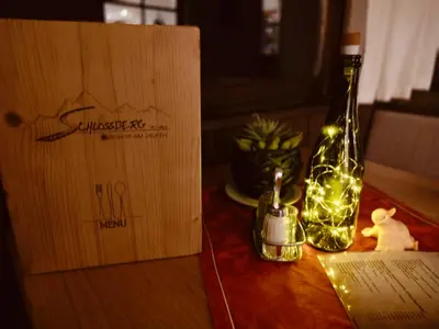 a bottle with lights on a table next to a box at Schlossberg in San Leonardo in Passiria