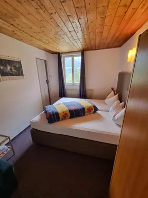 a bedroom with a large bed with a wooden ceiling at Schlossberg in San Leonardo in Passiria