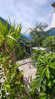 a bench sitting on a patio with mountains in the background at Schlossberg in San Leonardo in Passiria