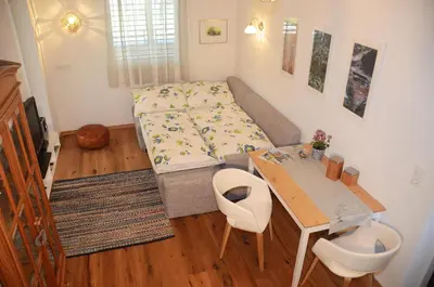 a small room with a bed and a table at Apartment Zimat in Chienes