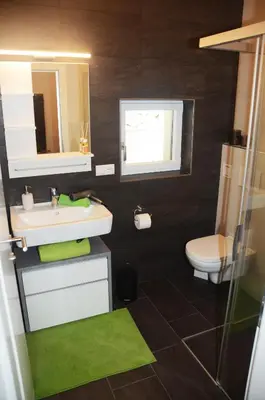a bathroom with a sink and a toilet and a mirror at Apartment Zimat in Chienes