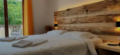 a bedroom with a large bed with a wooden wall at Hotel Ganzaie in Daiano