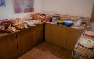 a kitchen with wooden cabinets with food on the counters at Hotel Ganzaie in Daiano