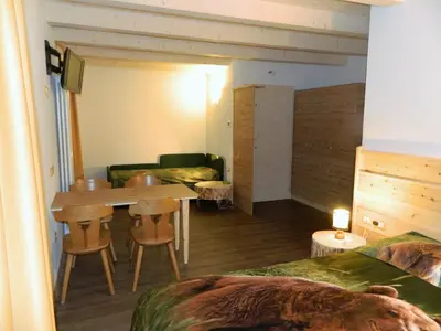 a room with a table and chairs and a couch at Hotel Ganzaie in Daiano