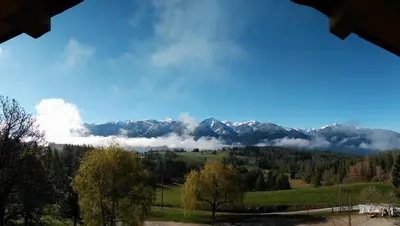 a view of a mountain range with clouds in the sky at Hotel Ganzaie in Daiano