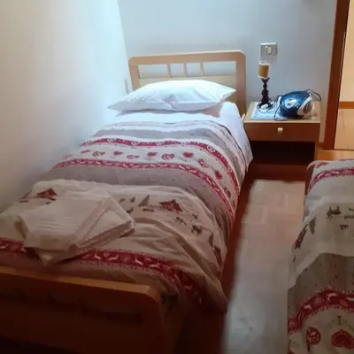a bed with a red and white blanket on it at il Nido in Tonadico
