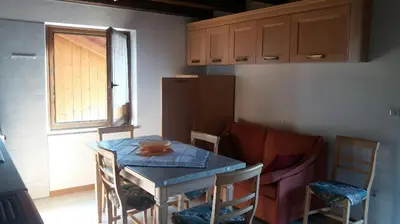 a kitchen with a table and chairs and a table and a table and a kitchen at il Nido in Tonadico