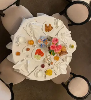 an overhead view of a white table with plates and flowers at Classic Hotel Meranerhof in Merano