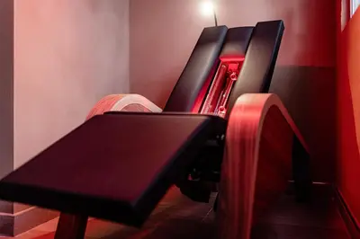 a black bench in a room with a red wall at Classic Hotel Meranerhof in Merano
