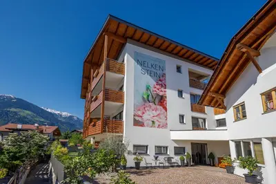 a building with a sign on the side of it at Residence Apartment Nelkenstein in Schenna