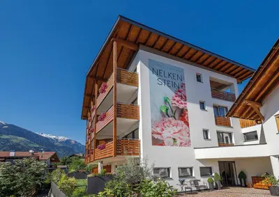a building with a sign on the side of it at Residence Apartment Nelkenstein in Schenna
