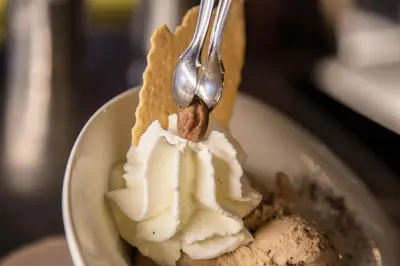 a spoon is digging into a piece of ice cream at Alpenhotel La Montanara in Rocca Pietore