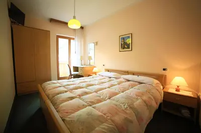 a bedroom with a large bed in a room at Alpenhotel La Montanara in Rocca Pietore