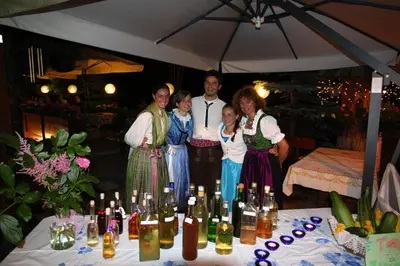 a group of people standing next to a table with bottles of wine at Alpenhotel La Montanara in Rocca Pietore