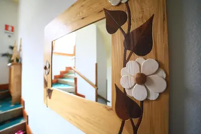 a mirror on a wooden door with flowers on it at Alpenhotel La Montanara in Rocca Pietore