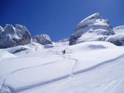 a person is skiing down a snow covered mountain at Alpenhotel La Montanara in Rocca Pietore