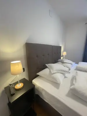 a bedroom with a bed with a lamp on a table at Gasthof Majestic in Bressanone