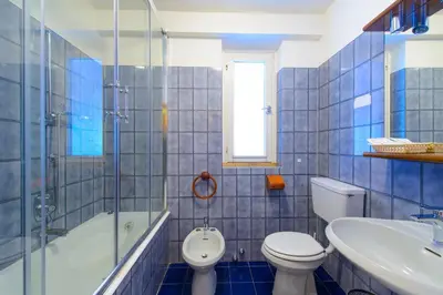 a bathroom with a toilet and a tub and a sink at Park Hotel Faloria in Canazei