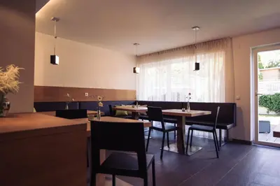 a dining room with tables and chairs and a window at Residence Panorama in Brunico