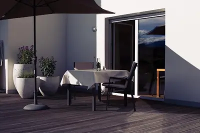a dining room with a table and chairs and an umbrella at Residence Panorama in Brunico