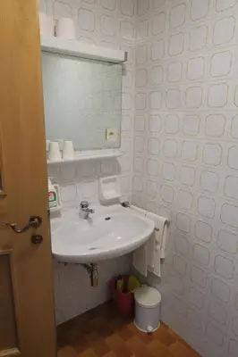 a white bathroom with a sink and a mirror at Residence Scheidnerhof in Aldino