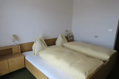 a bed with white sheets and pillows on it at Residence Scheidnerhof in Aldino