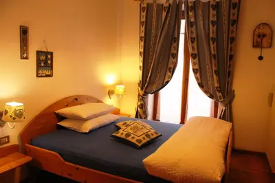 a bedroom with a bed with pillows and a window at Garni Biancaneve Ruffrè-Mendola in Mendola