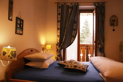 a bedroom with a bed with two pillows and a window at Garni Biancaneve Ruffrè-Mendola in Mendola