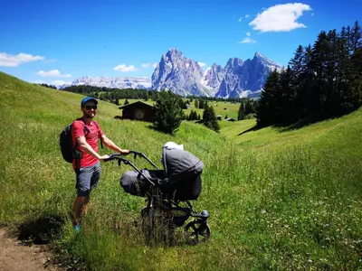 a man standing next to a bike in a field at Apartments Schlossblick Naturholz in Vols am Schlern