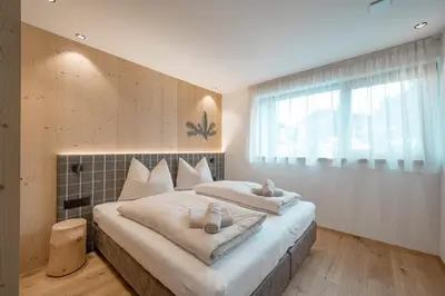 a bedroom with a large bed with towels on it at Walderhof Natz in Naz-Sciaves