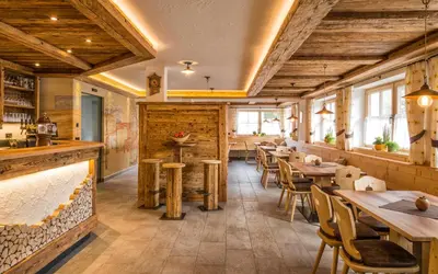 a restaurant with wooden ceilings and tables and chairs at Walderhof Natz in Naz-Sciaves