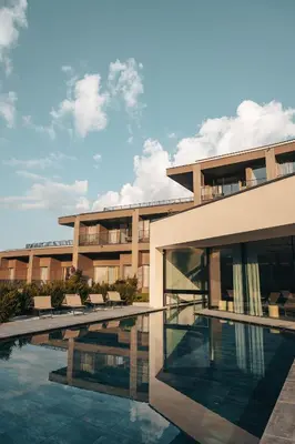 a building with a swimming pool in front of it at Das Mühlwald - Quality Time Family Resort in Naz-Sciaves