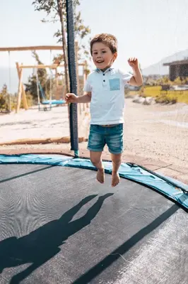 a young boy jumping on a trampoline at Das Mühlwald - Quality Time Family Resort in Naz-Sciaves