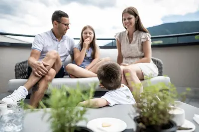 a group of people sitting around a table at Das Mühlwald - Quality Time Family Resort in Naz-Sciaves