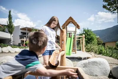 a boy and a girl playing in a playground at Das Mühlwald - Quality Time Family Resort in Naz-Sciaves