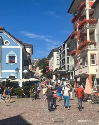 a group of people walking down a street with buildings at B&B Lavi Ortisei val Gardena in Ortisei
