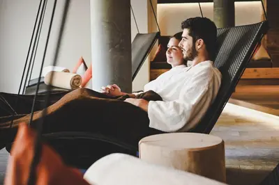 two men sitting in a hammock at Wiesenhof Gardenresort in San Leonardo in Passiria