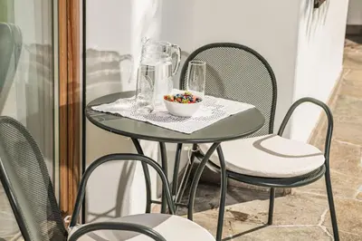 a small table with chairs and a bowl of candy at Residence Cesa Ladina in Ortisei