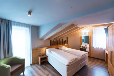 a bedroom with a large bed and a staircase at Chalet Vites Mountain Hotel in Canazei
