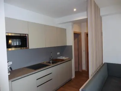 a kitchen with white cabinets and a sink at Hotel Flora in Lagundo