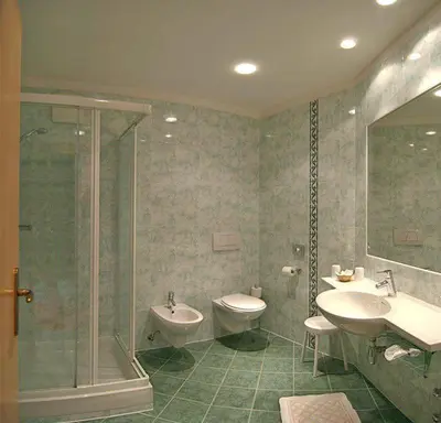a bathroom with two sinks and a shower and a toilet at Hotel Flora in Lagundo