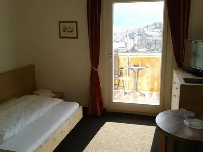 a bedroom with a bed and a large window at Hotel Flora in Lagundo