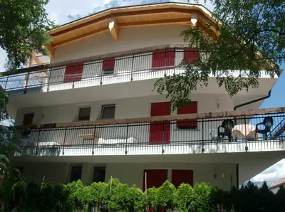 a building with a balcony on top of it at Pension Flora in Ora/Auer