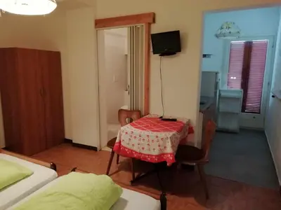 a small room with a table and a bed at Pension Flora in Ora/Auer