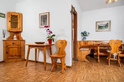 a room with a table and chairs and a desk at Residence Weiss in Vigo di Fassa