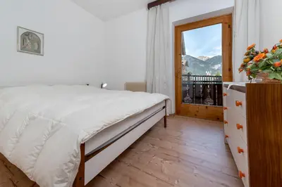 a bedroom with a bed and a window at Residence Weiss in Vigo di Fassa