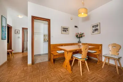 a dining room with a wooden table and chairs at Residence Weiss in Vigo di Fassa