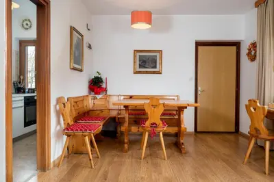 a dining room with a wooden table and chairs at Residence Weiss in Vigo di Fassa